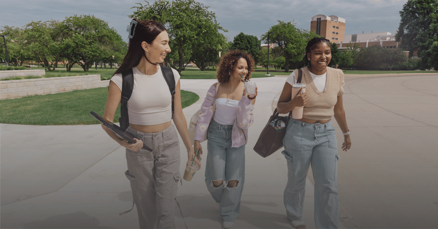 3 female students happily walking on campus