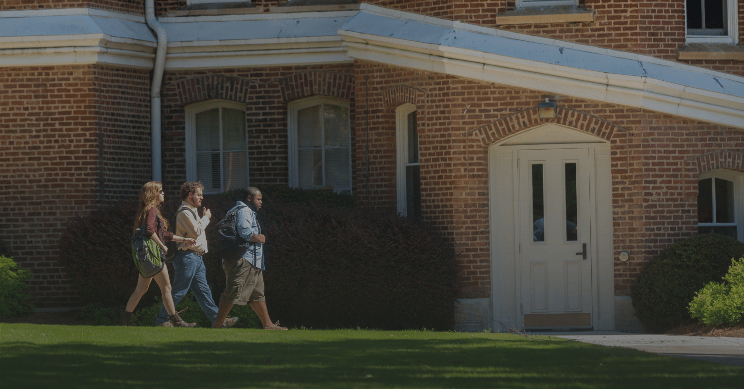 3 students walking on grass