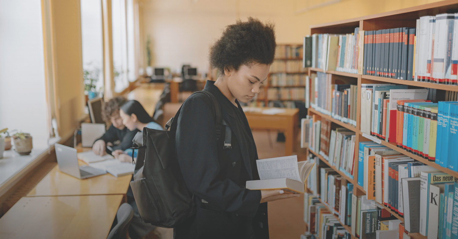 Girl standing in the library reading a book