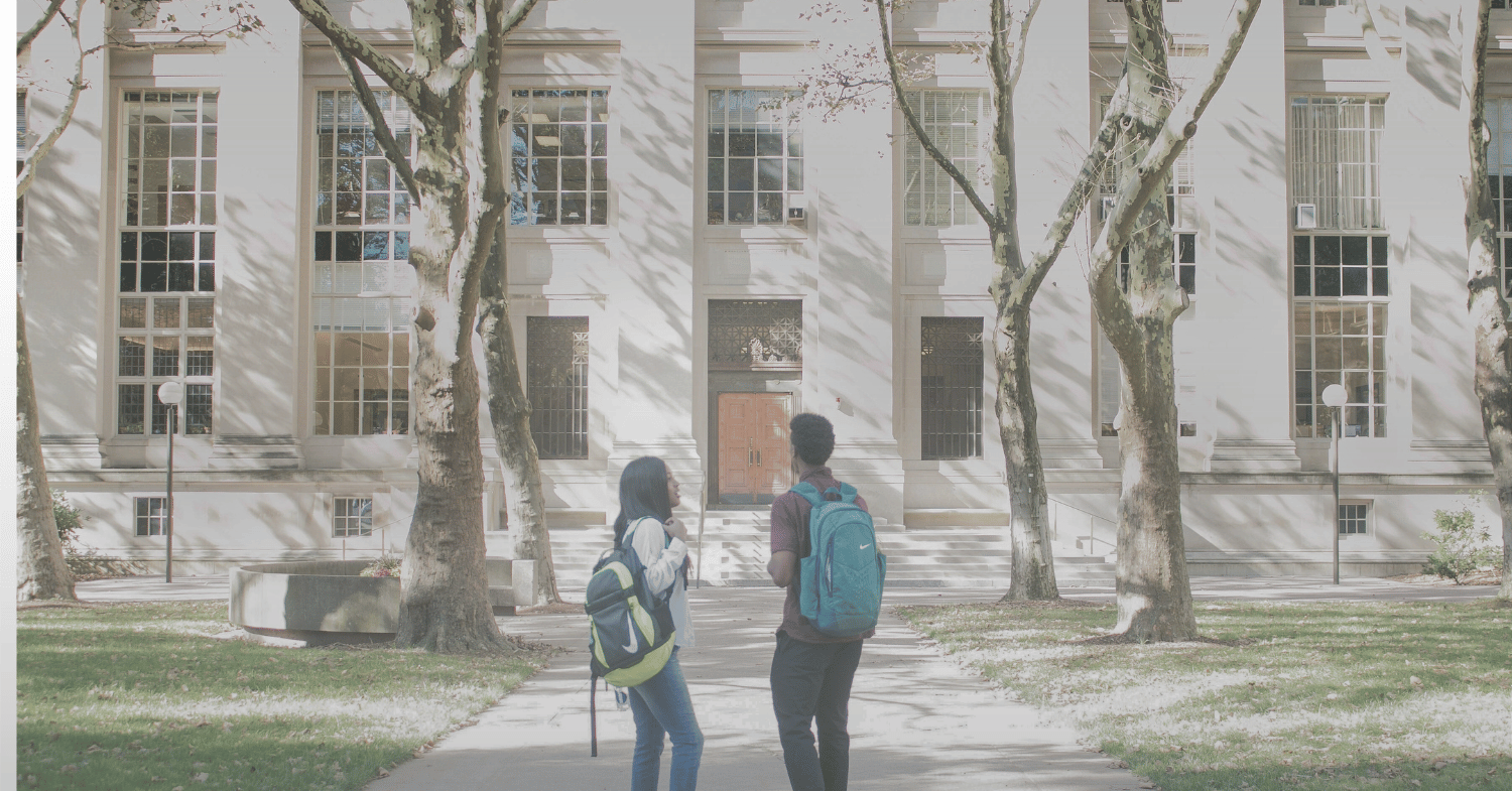 two students standing outside university building