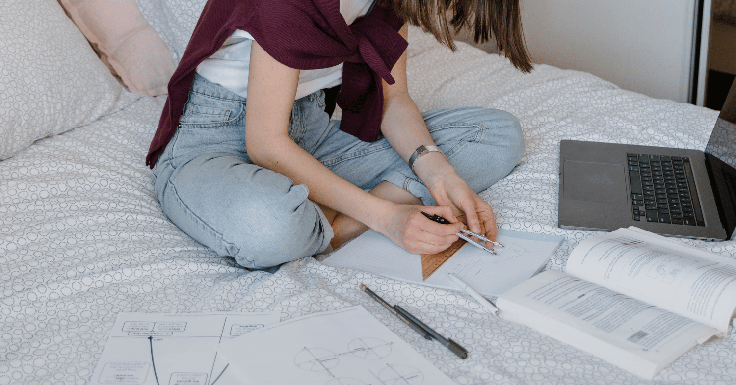 A student studying maths in bed