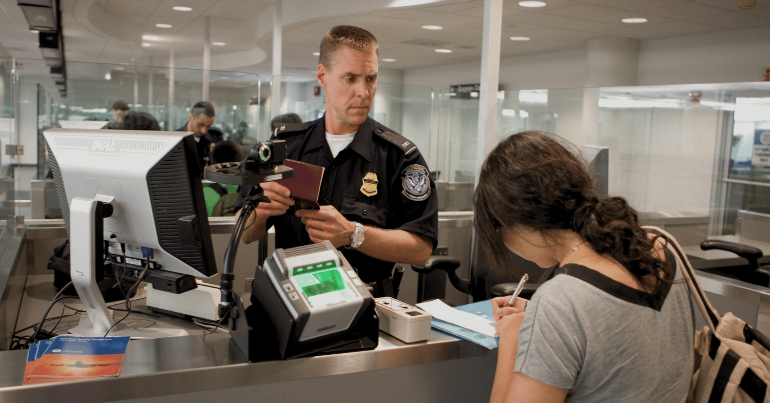 A US border officer checking a student's passport